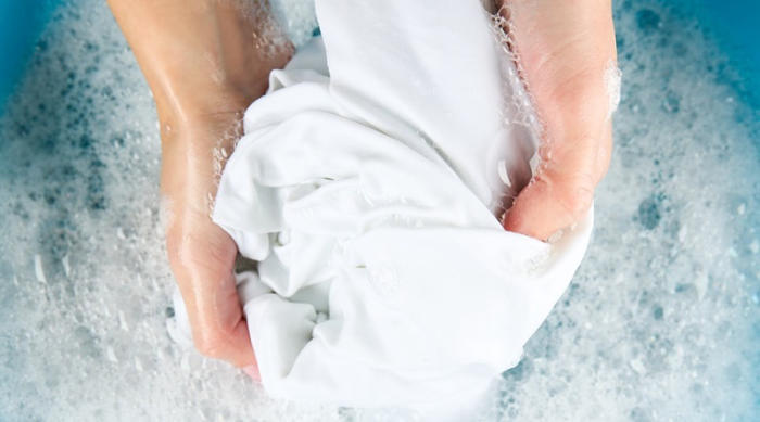 Giặt áo sơ mi trắng bằng tay giúp áo tránh bị bám màu khi giặt chung với các loại đồ khác